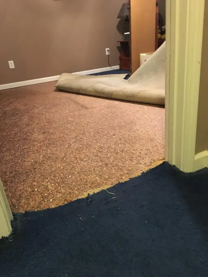 Carpet pad removal revealing water damage during Water Mitigation Services in Rock Springs